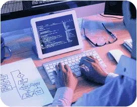 A sitting person typing on keyboard and looking into the tablet.